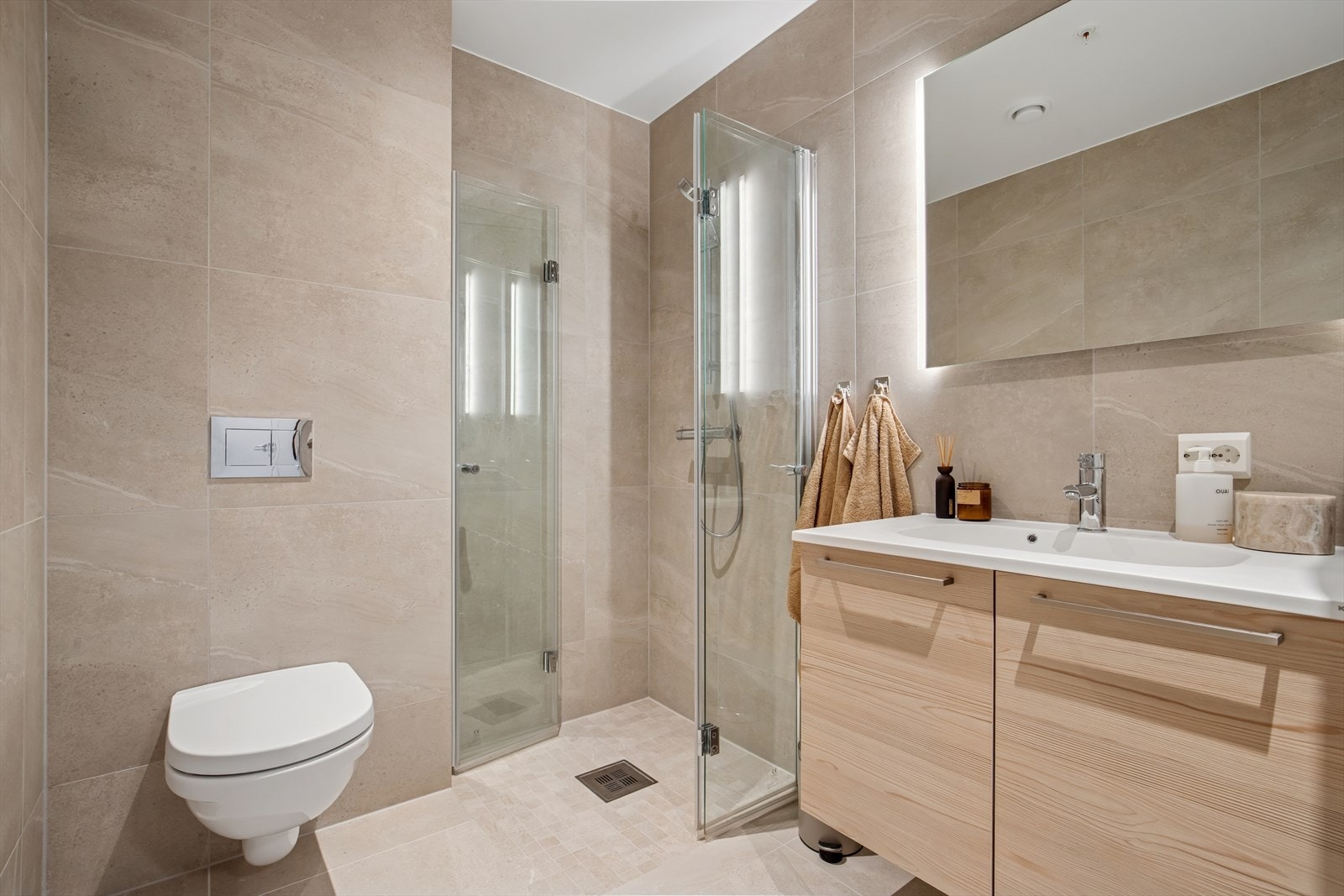 Badet er ellers utstyrt med dusjhjørne med innfellbare dusjvegger, vegghengt toalett og baderomsinnredning med god lagringsplass og nedfelt servant. I tillegg har man opplegg for vaskemaskin og plass til tørketrommel. Galleribilde