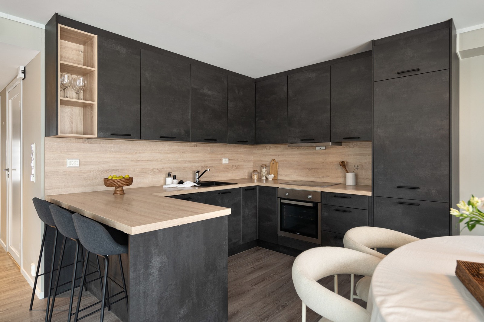 Integrerte hvitevarer og kjøkkenøy/skråstilt barløsning gir både funksjonalitet og sosiale soner. Galleribilde