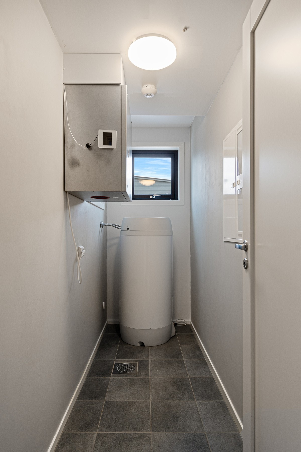 Praktisk vaskerom med opplegg for vaskemaskin og tørketrommel. God oppbevaringsplass og funksjonell løsning som gjør hverdagen enklere. Galleribilde