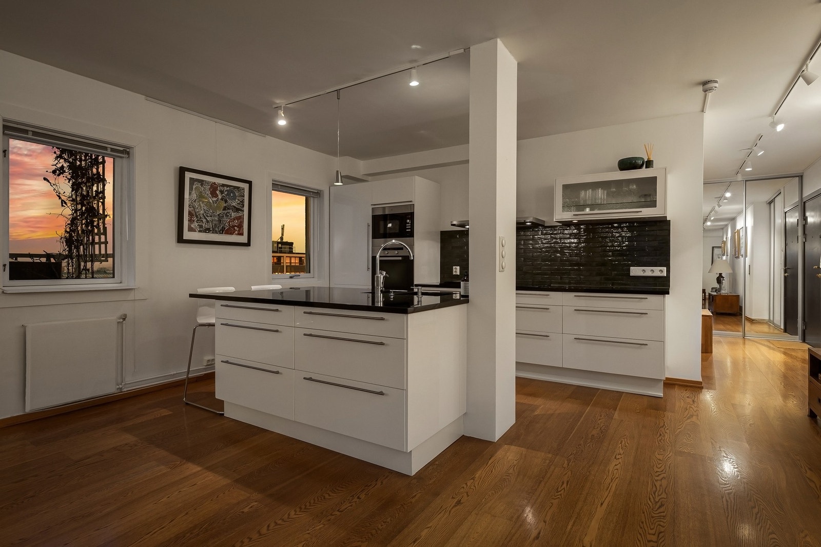 Kjøkken med slette, hvite fronter og benkeplate i stein som gir et moderne og helhetlig uttrykk. Galleribilde