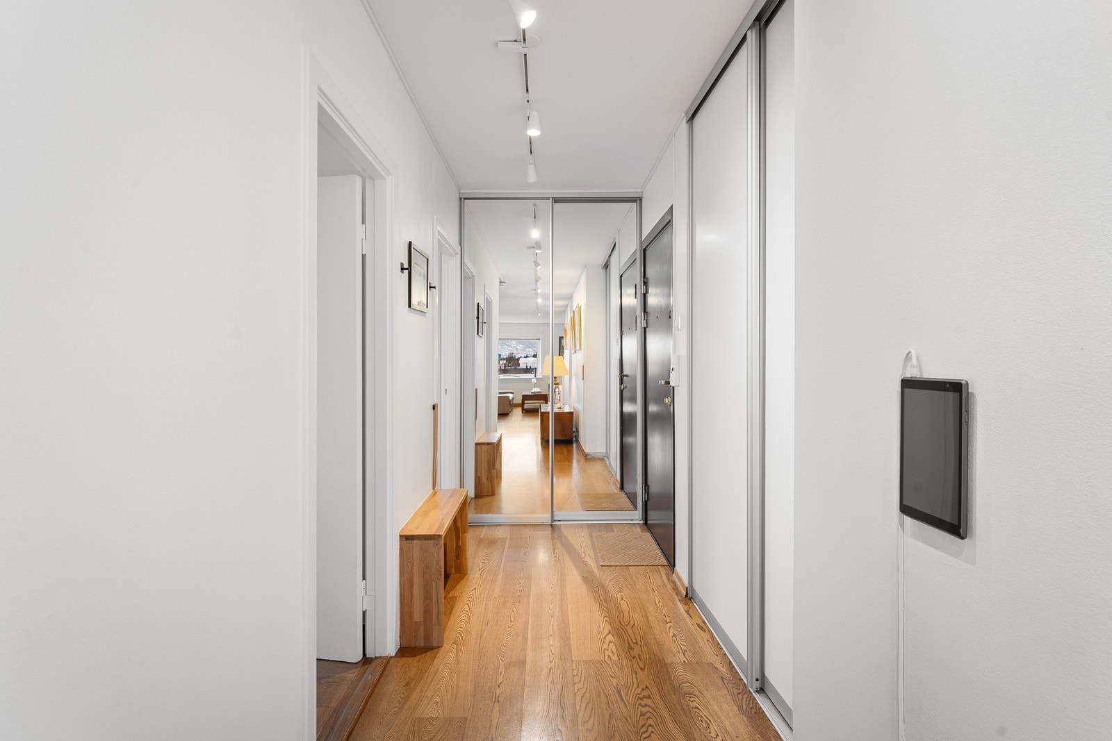 Romslig entré med gode oppbevaringsmuligheter i skyvedørsgarderobe med speilfronter. Galleribilde