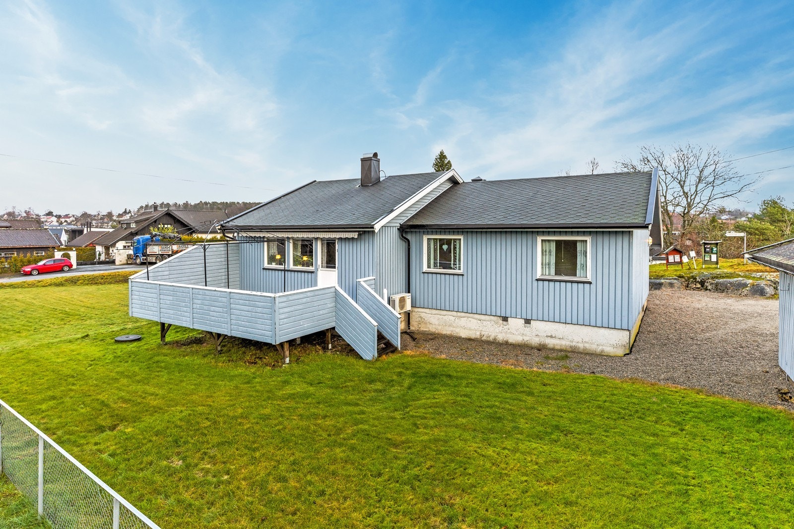 Gruset innkjørsel leder til boligen. Galleribilde