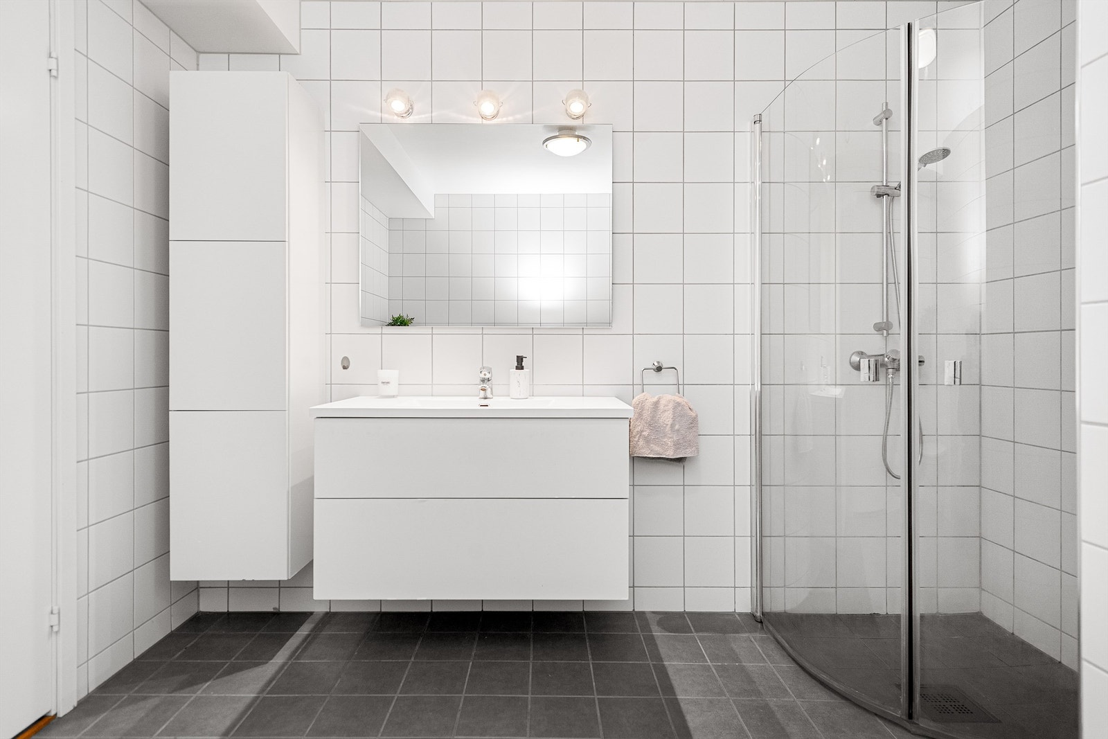 Badet er utstyrt med baderomsinnredning, vegghengt toalett og dusjhjørne Galleribilde