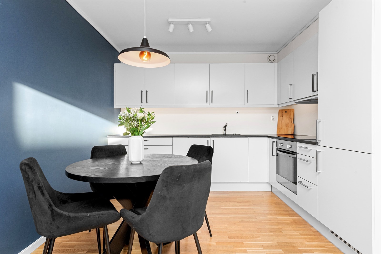 Hvit kjøkkeninnredning med under- og overskap, glatte fronter Galleribilde