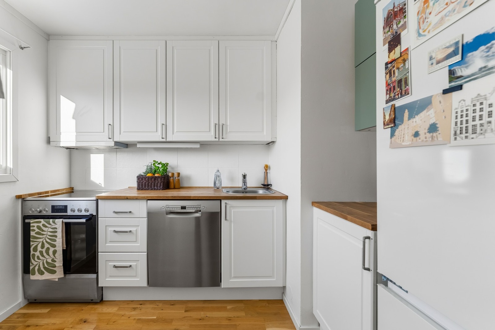 Separat kjøkken av ukjent årstall med klassiske kremhvite fronter og foring opp til tak. Benkeplate i heltre med nedfelt vaskekum i rustfritt stål. Galleribilde