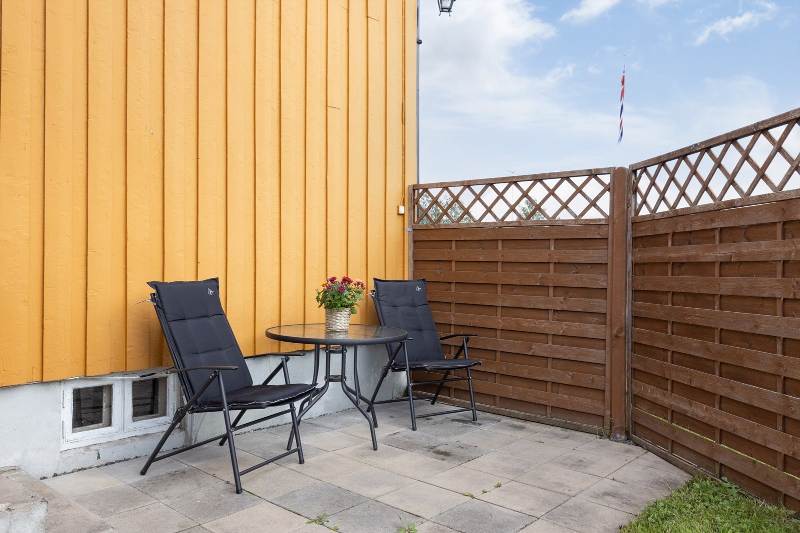 Via balkongen er det adkomst til en koselig og lun uteplass med hellebelagt underlag og levegg. Galleribilde