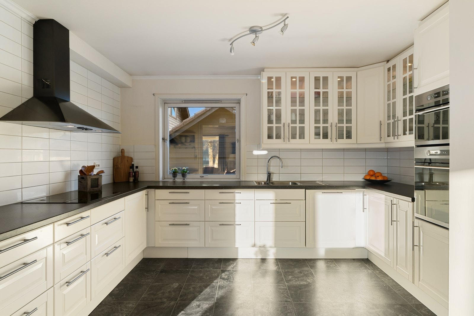 Romslig kjøkken med profilerte fronter og benkeplate av laminat med nedfelt vask. Vindu som slipper rikelig med lys inn. Galleribilde