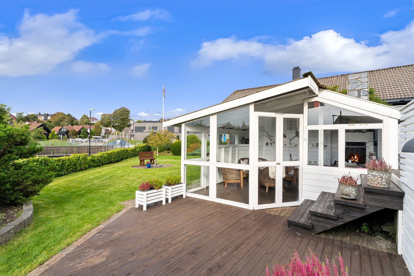 Stor hage med plen og vintergrønn beplantning. Terrasser med levegger som skjerming. Galleribilde