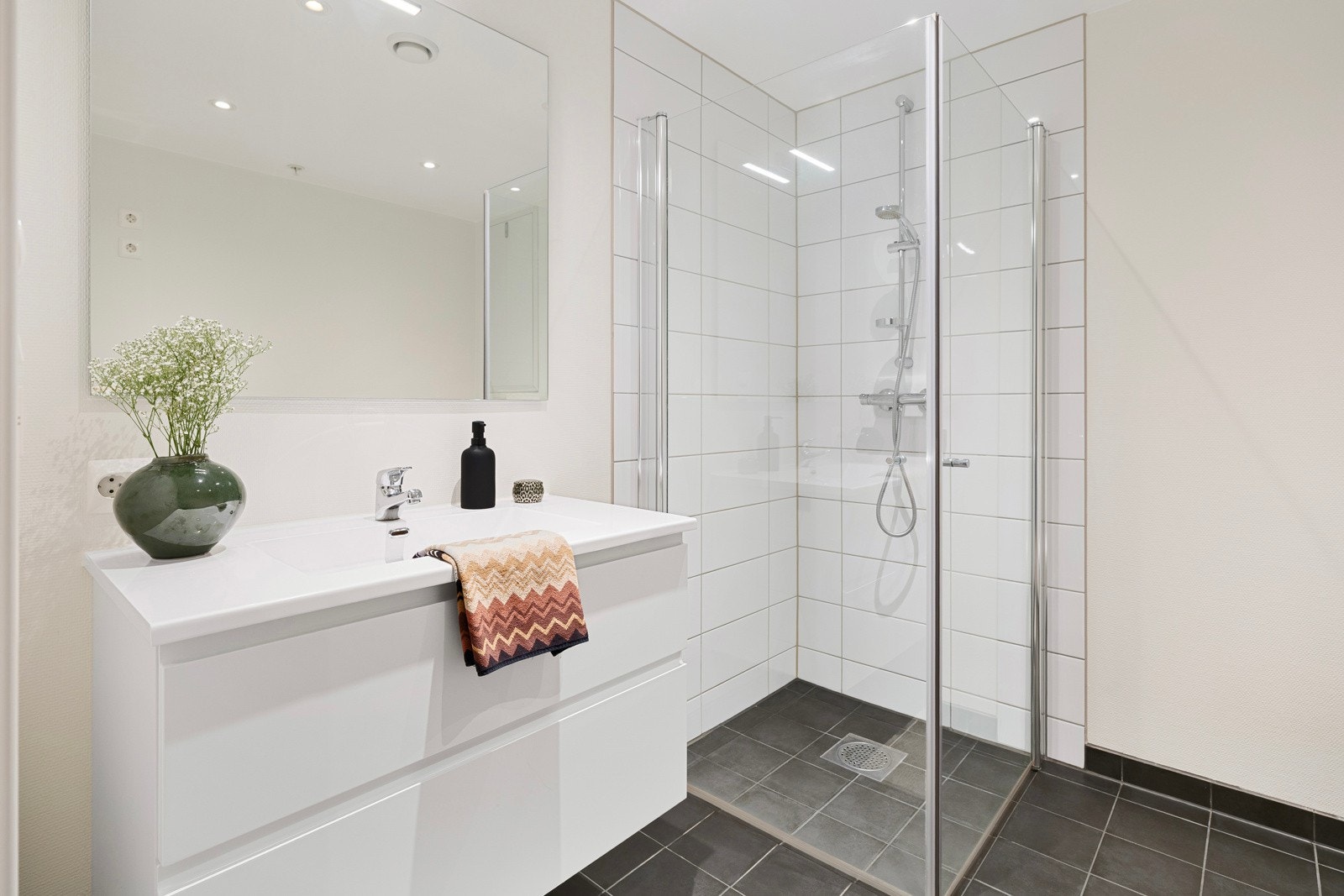 Pent innredet, romslig bad med fliser på gulv og i dusjsonen Galleribilde