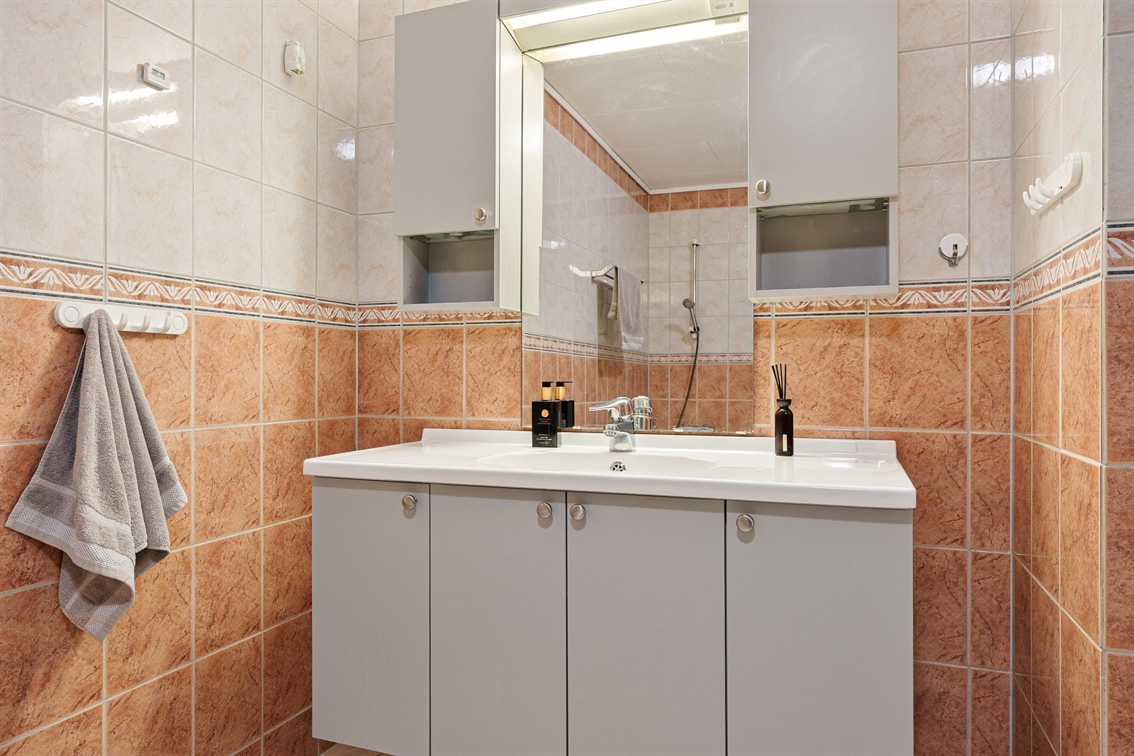 Badet er utstyrt med innfliset badekar, toalett, dusjkabinett og baderomsinnredning med heldekkende servant og belyst speil. Galleribilde