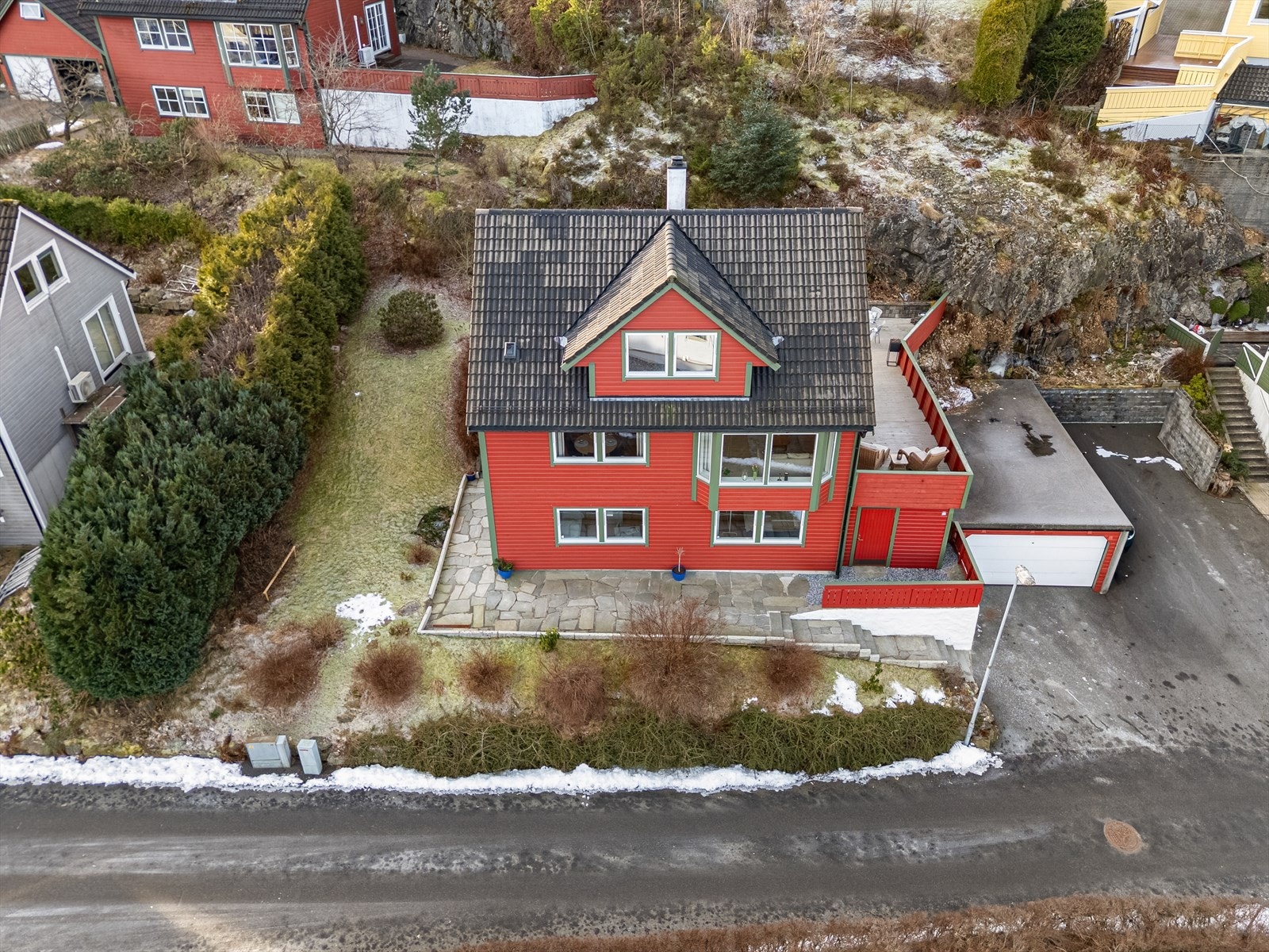 Tomten er pent opparbeidet med asfaltert innkjørsel, garasje, hage og hyggelige uteplasser med skiferheller og terrasse. Galleribilde