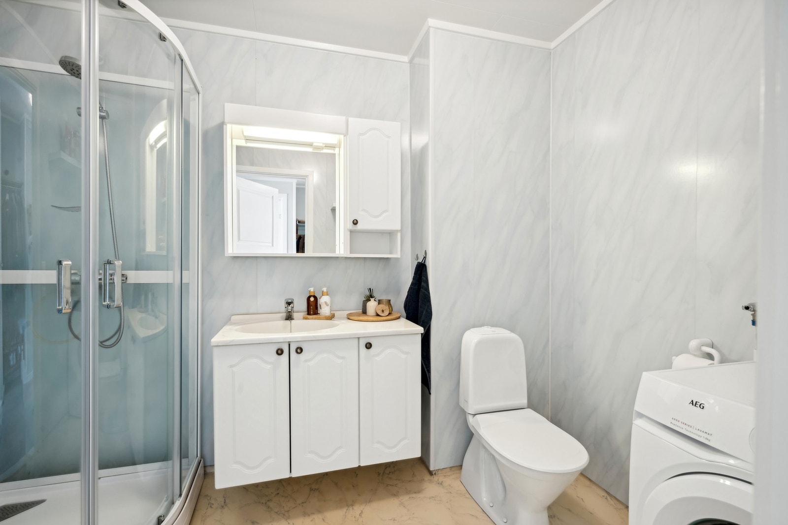 Badet er fra byggeår med belegg på gulv og våtromsplater på vegg. Galleribilde