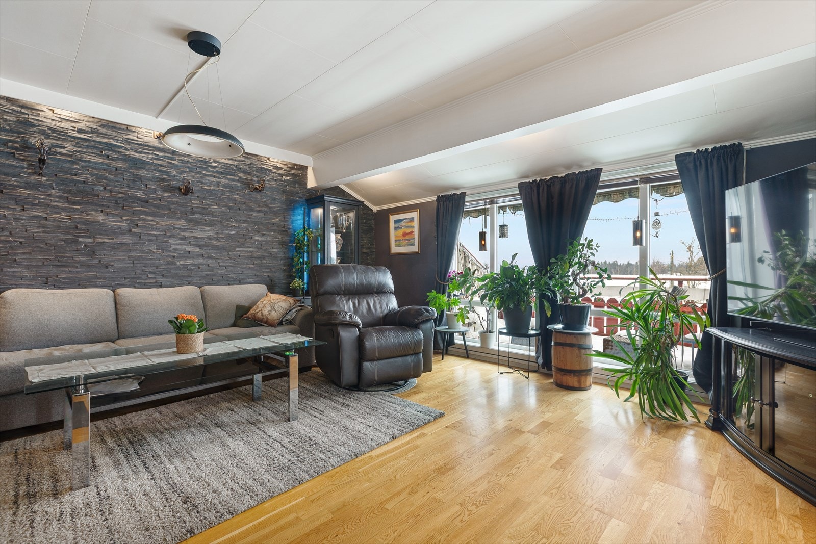 Store vindusflater i stuen gir godt med dagslys og leder ut til balkongen. Galleribilde