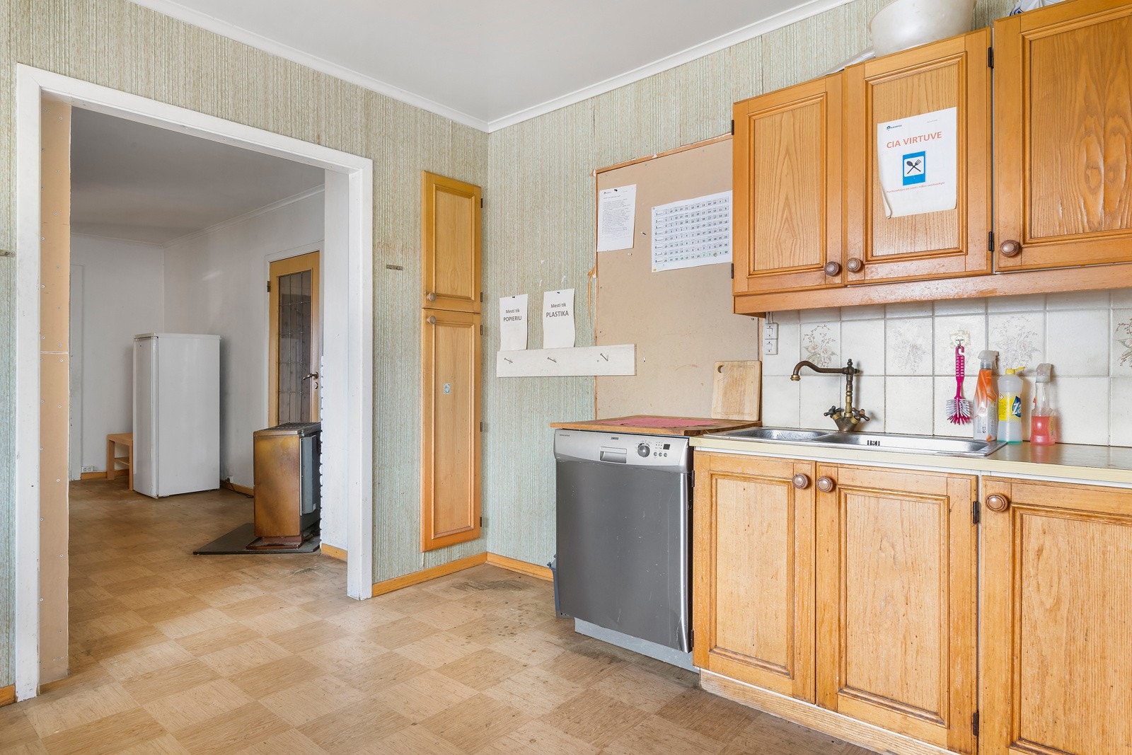 Nedfelt oppvaskkum av rustfritt stål og avtrekksvifte over komfyren. Galleribilde