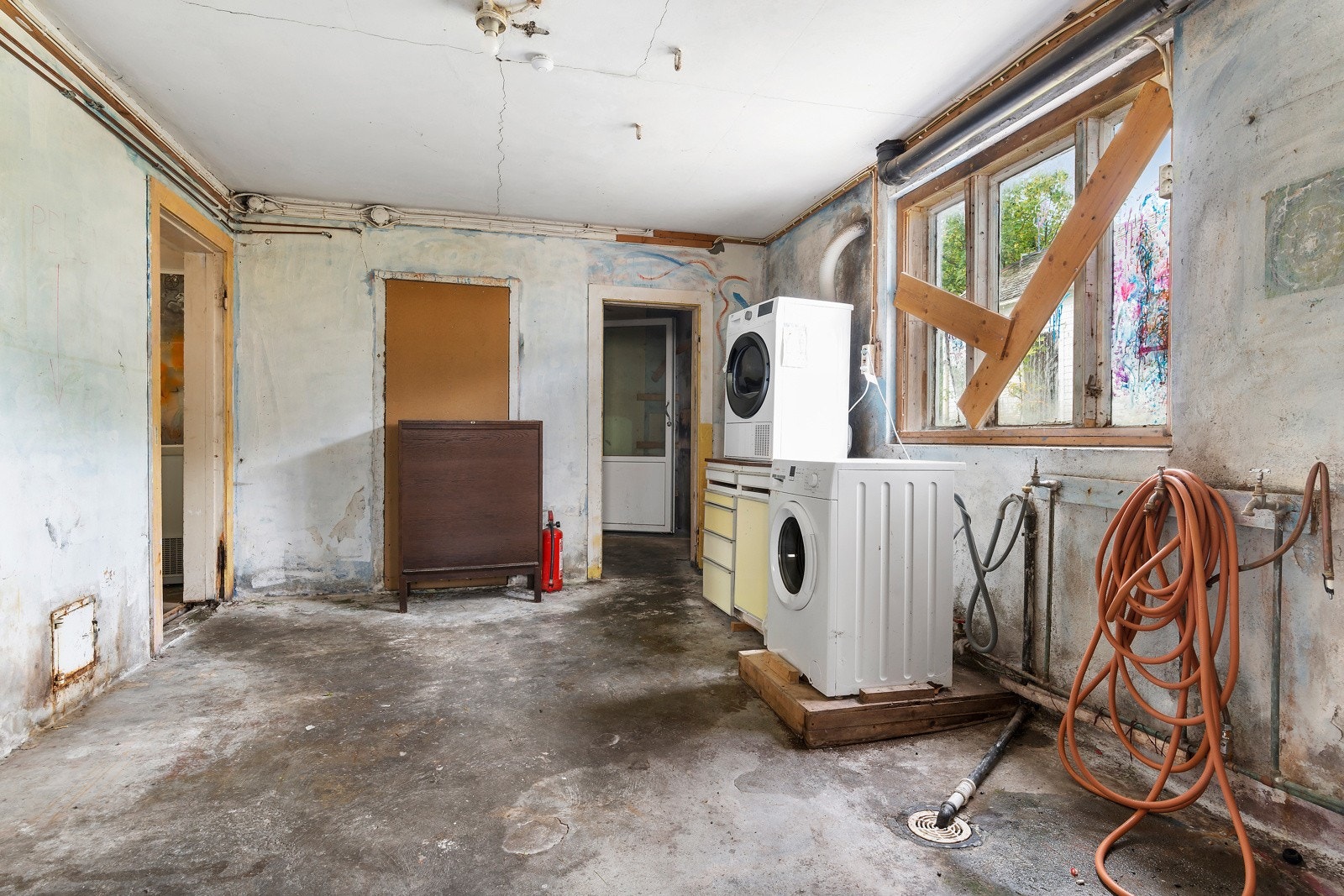 Vaskerommet har betonggulv og pussende murvegger. Plastsluk av nyere type i gulv. Galleribilde