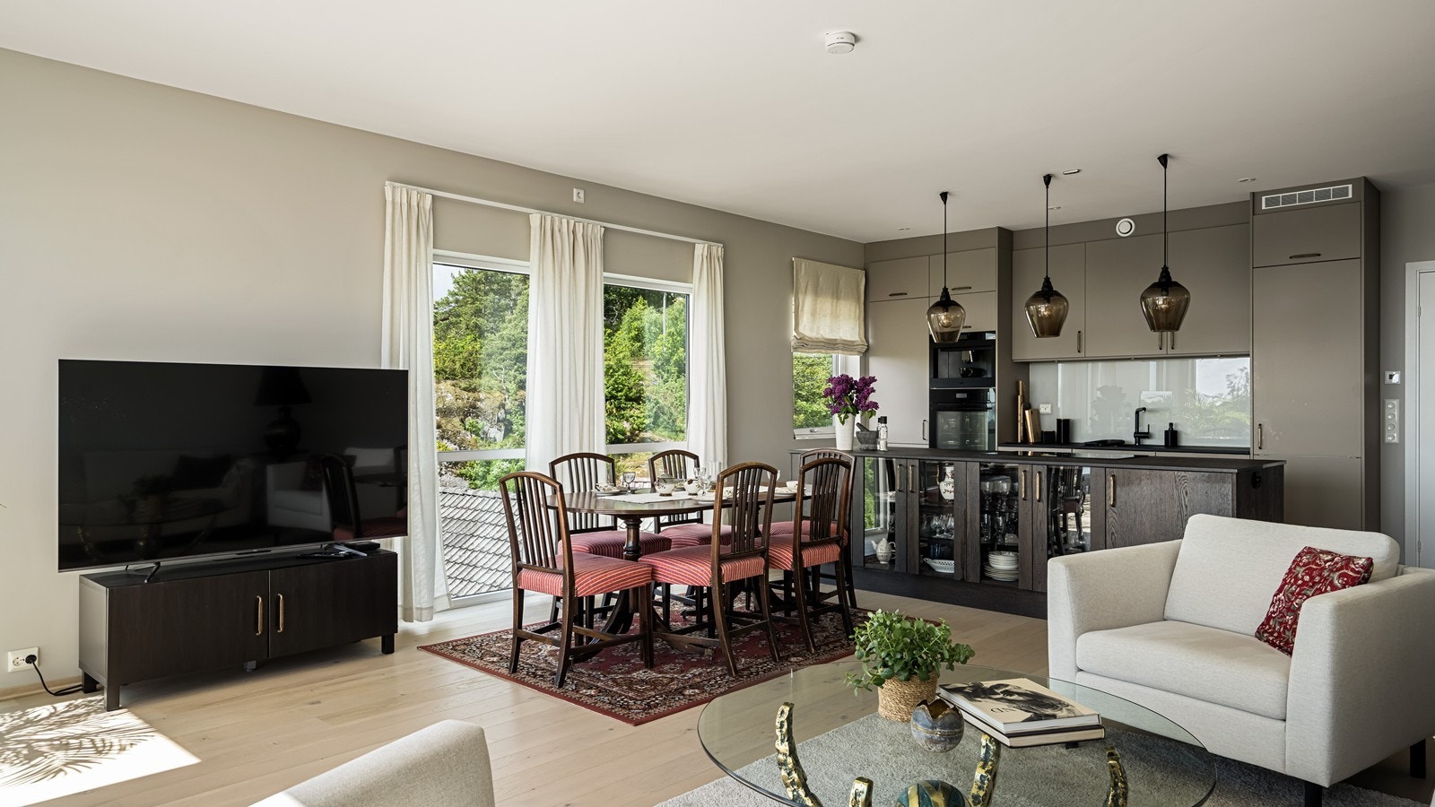 God plass til stor sofagruppe, bord og tv med tilhørende møblement Galleribilde