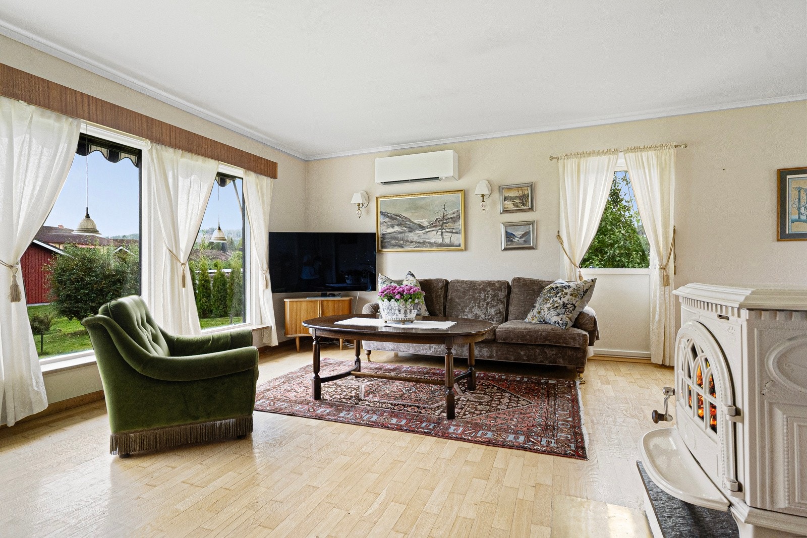 Lys og åpen stue med vinduer ut mot hagen Galleribilde