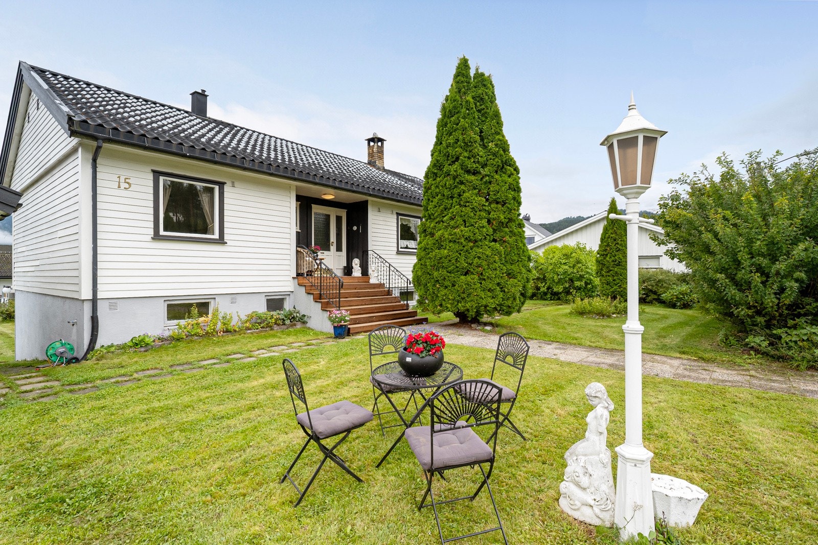 Stor, fin hage opparbeidet med plen og diverse beplantning Galleribilde