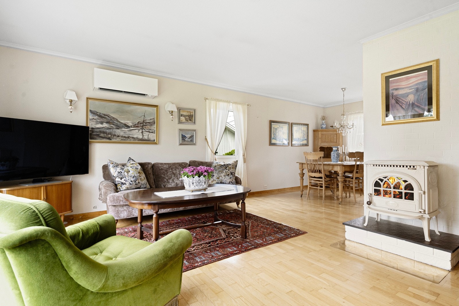 Det er både varmepumpe (ny 2023) og vedovn i stua Galleribilde