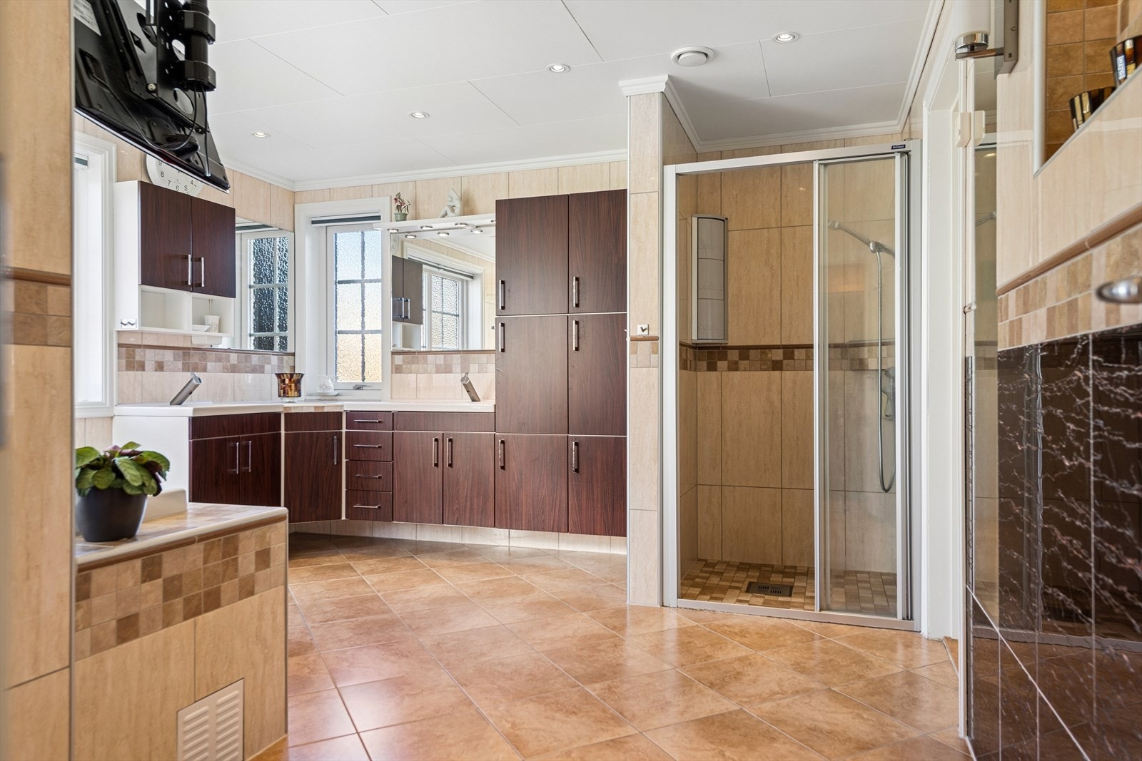 Badet er utstyrt med dobbel servant, rikelig med skapplass og en separat dusjnisje. Galleribilde