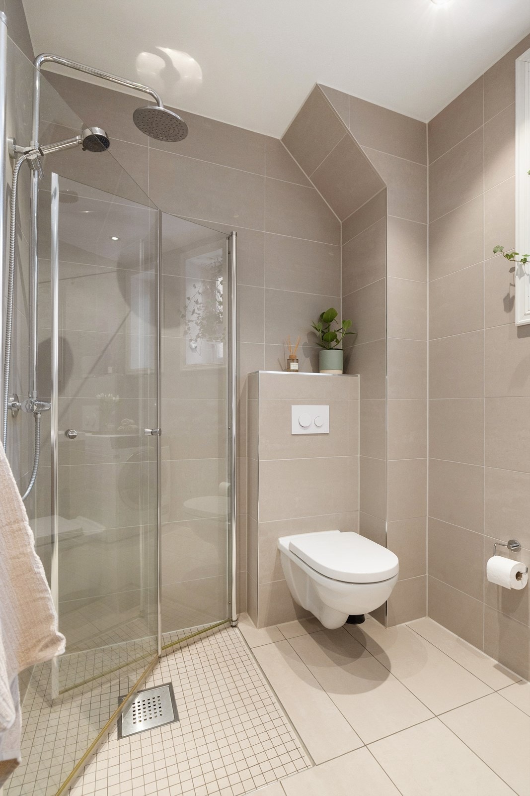 Videre har badet gulvvarme, opplegg for vaskemaskin, vegghengt toalett og dushjørne med glassdører. Galleribilde