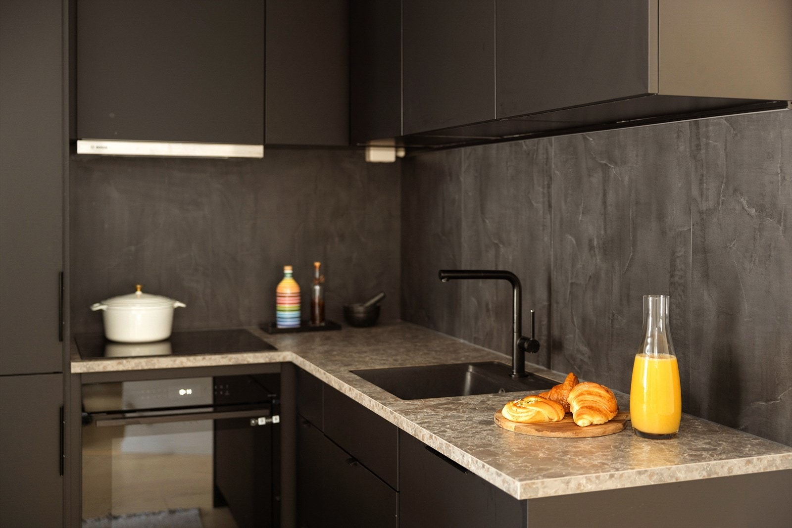 Benkeplate av laminat med underlimt kum. Det er montert komfyrvakt og vannstoppsystem. Galleribilde