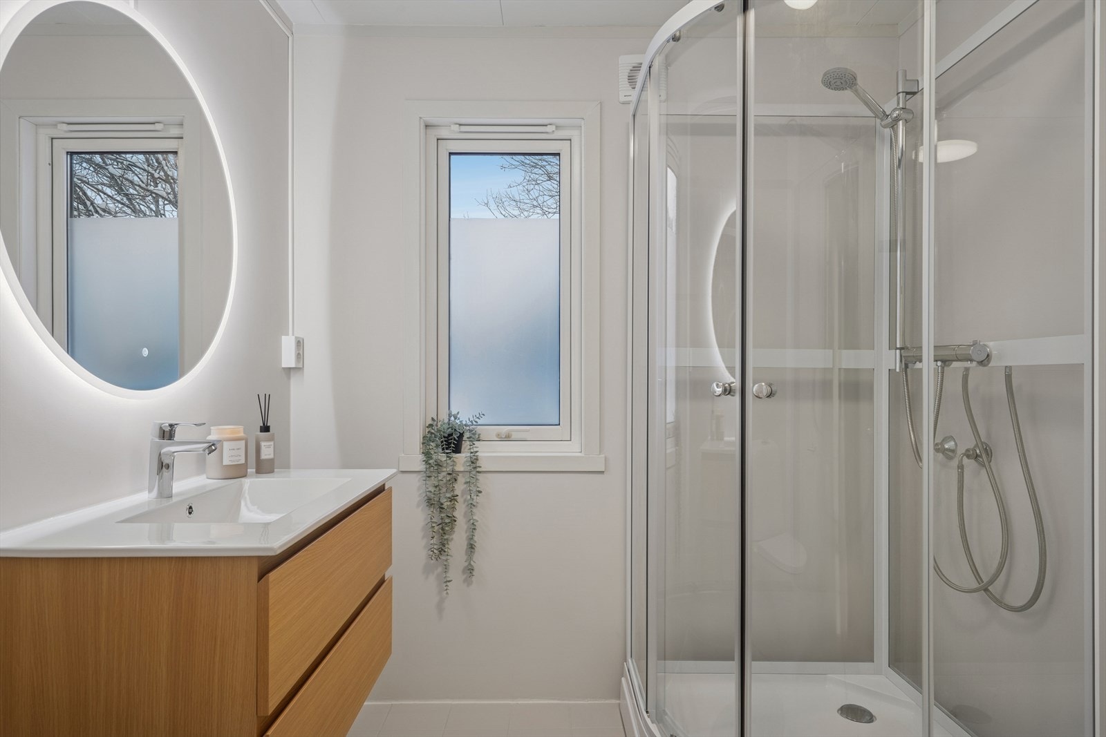 Badet er innredet med servant med innredning, speil og belysning samt dusjkabinett og toalett. Elektriske varmekabler i gulvet. Galleribilde