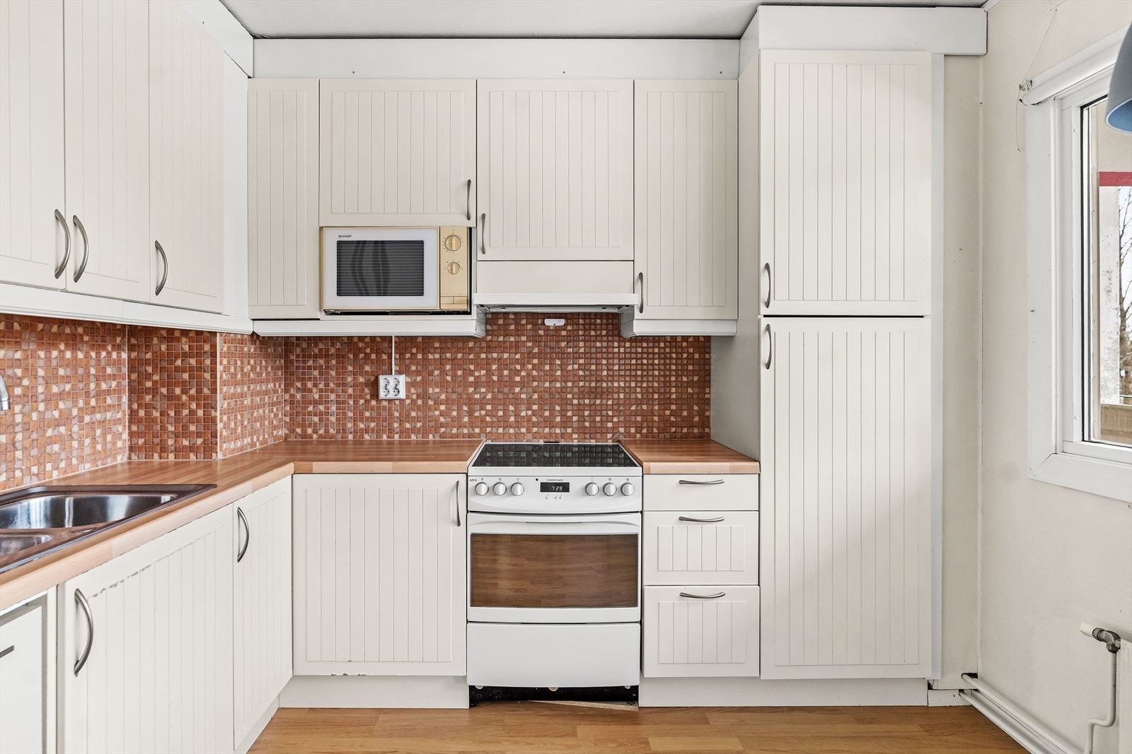 Videre er det plass til frittstående oppvaskmaskin, kjøl/fryseskap og komfyr med platetopp kullfiltervifte over stekesonen. Galleribilde