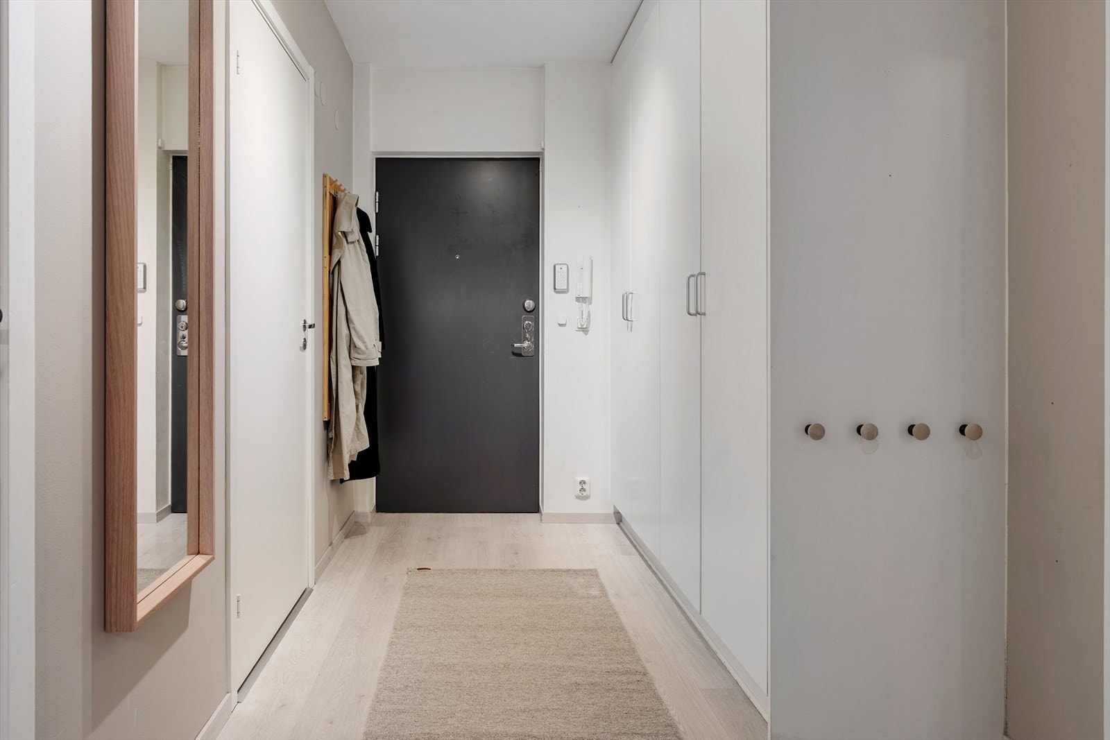 Romslig entré med plass til praktiske oppbevaringsløsninger. Det er montert porttelefon. Galleribilde