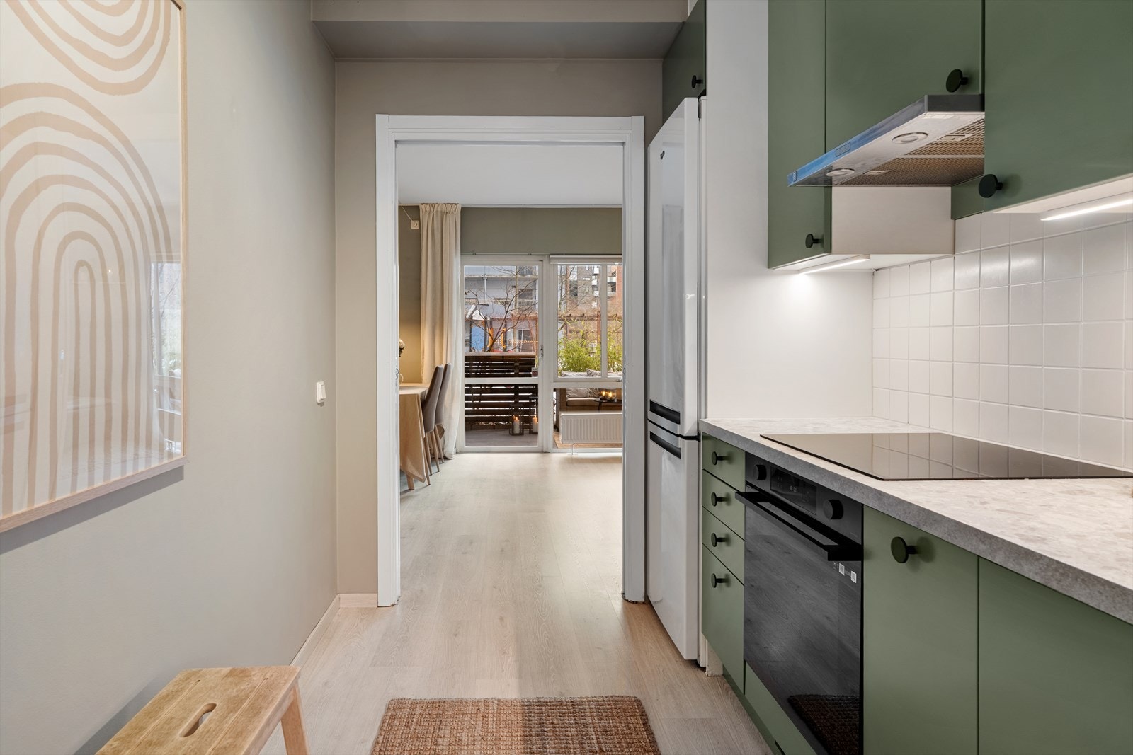 Kjøkkenet har en delvis åpen løsning mot stuen. Avsatt plass til frittstående kjøleskap integrert i innredningen (medfølger). Galleribilde