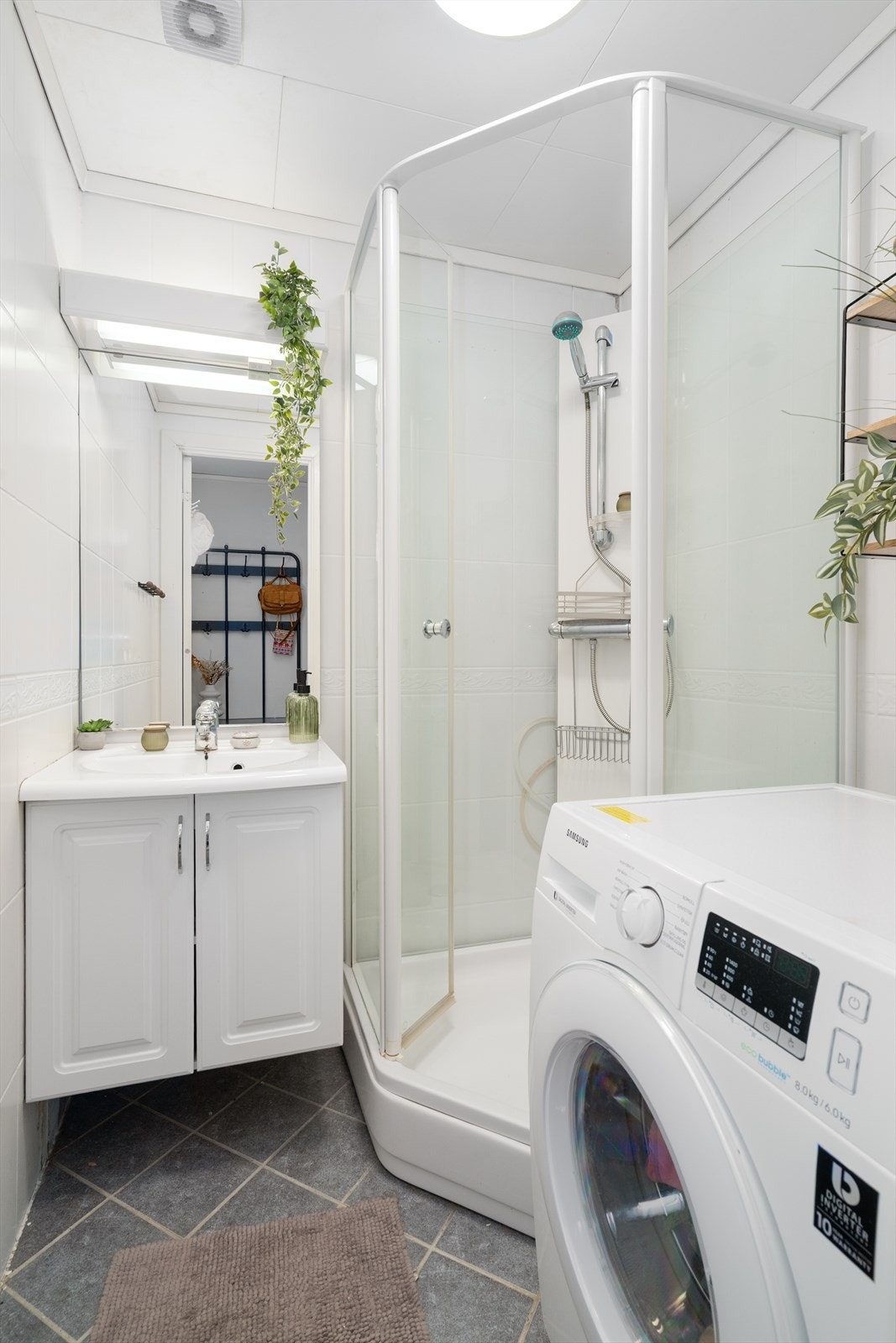 Pent baderom som er pusset opp i regi av borettslaget i 2008. Rommet er innredet med heldekkende servant med underskap, speil med lys over, dusjkabinett og opplegg til vaskemaskin. Galleribilde