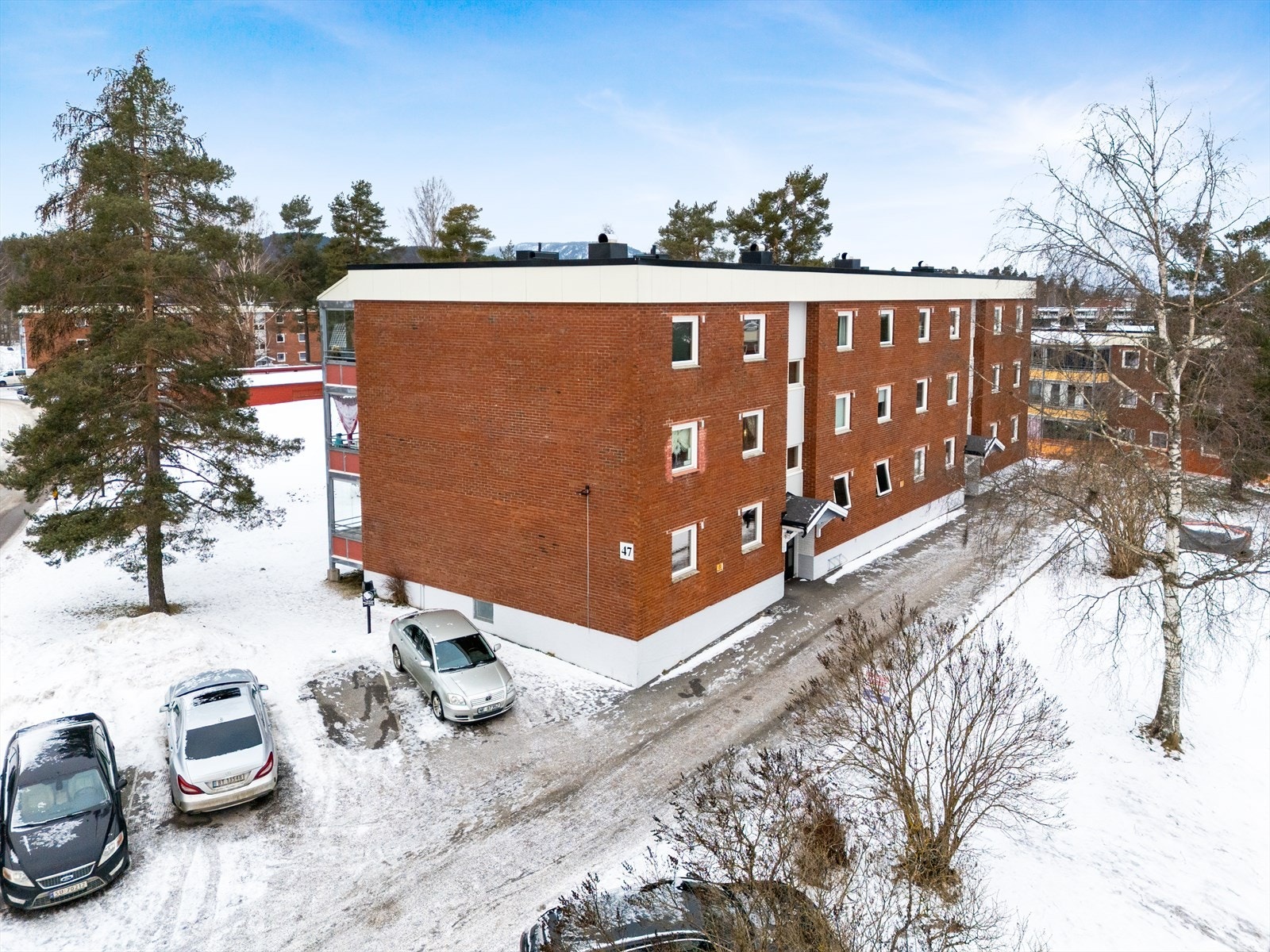 Felles biloppstillingsplasser på utsiden av blokka. Galleribilde