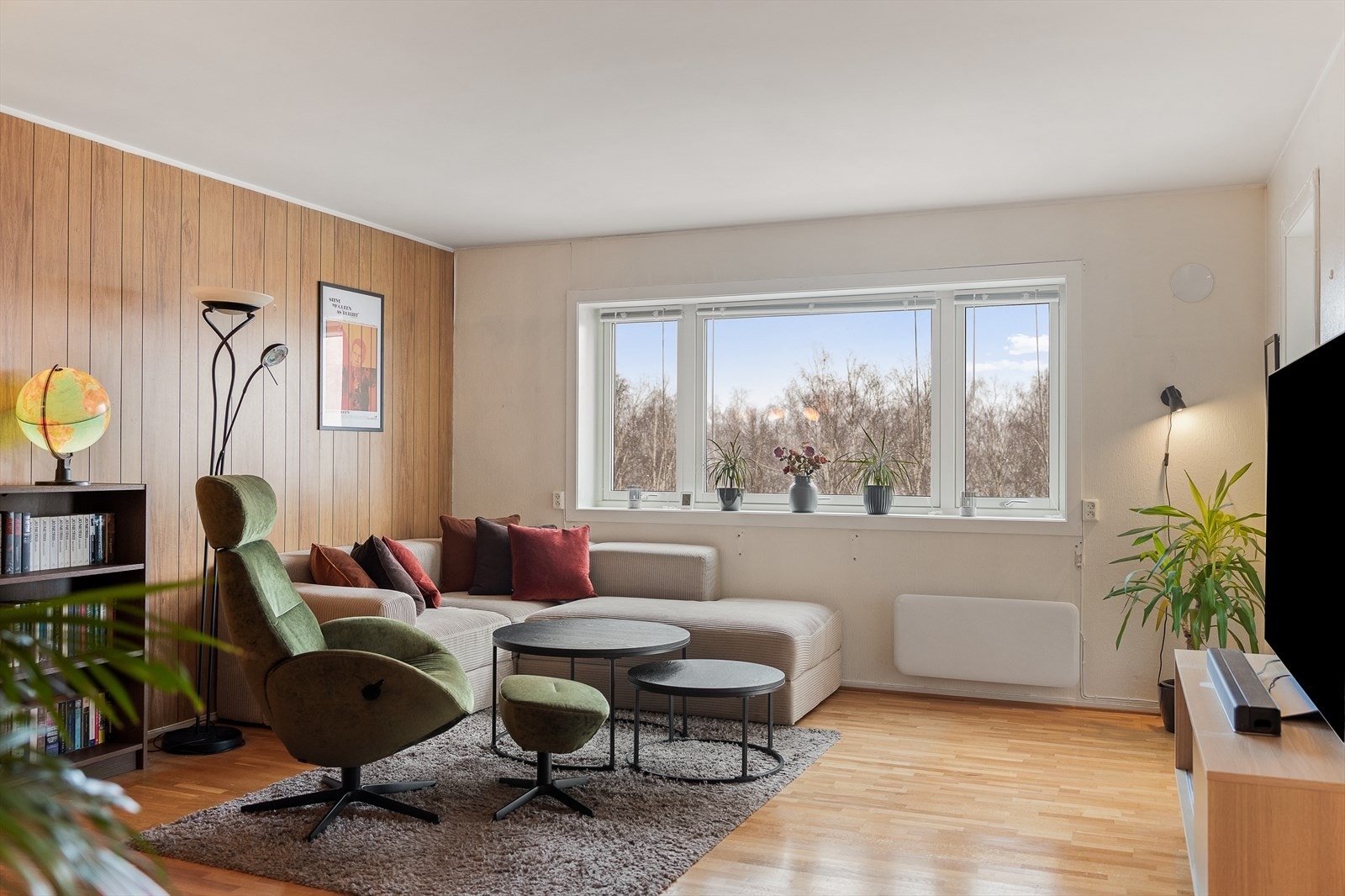 Lys og romslig stue med store vinduer som gir utsikt over det naturskjønne området utenfor. Galleribilde