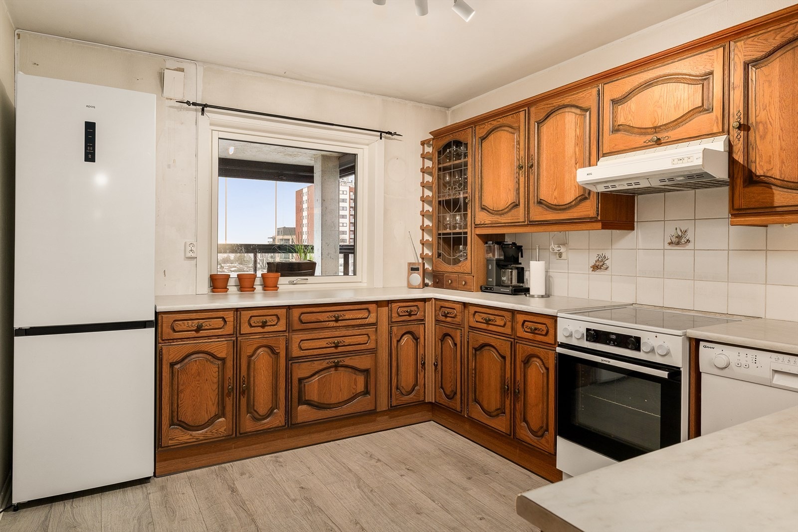 Romslig kjøkken med profilert innredning. Mye skap og benkeplass. Plass til kjøkkenbord og stoler. Innredning antatt fra 1990-tallet. Galleribilde