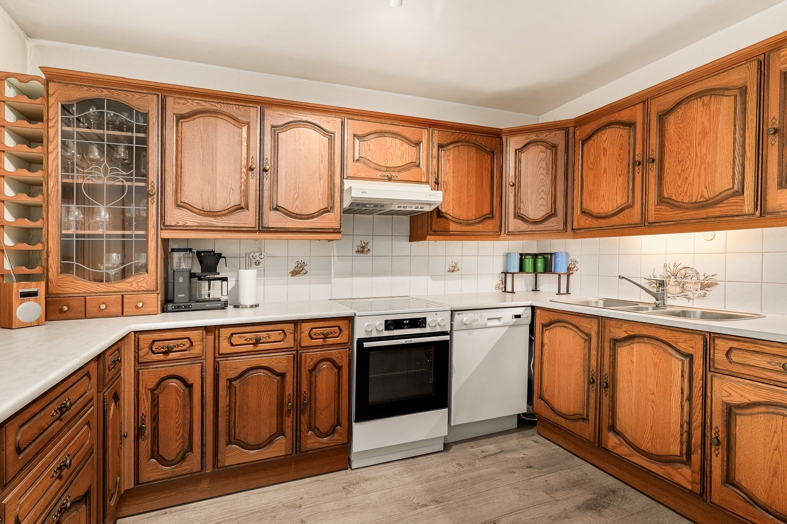 Romslig kjøkken med profilert innredning. Mye skap og benkeplass. Plass til kjøkkenbord og stoler. Innredning antatt fra 1990-tallet. Galleribilde