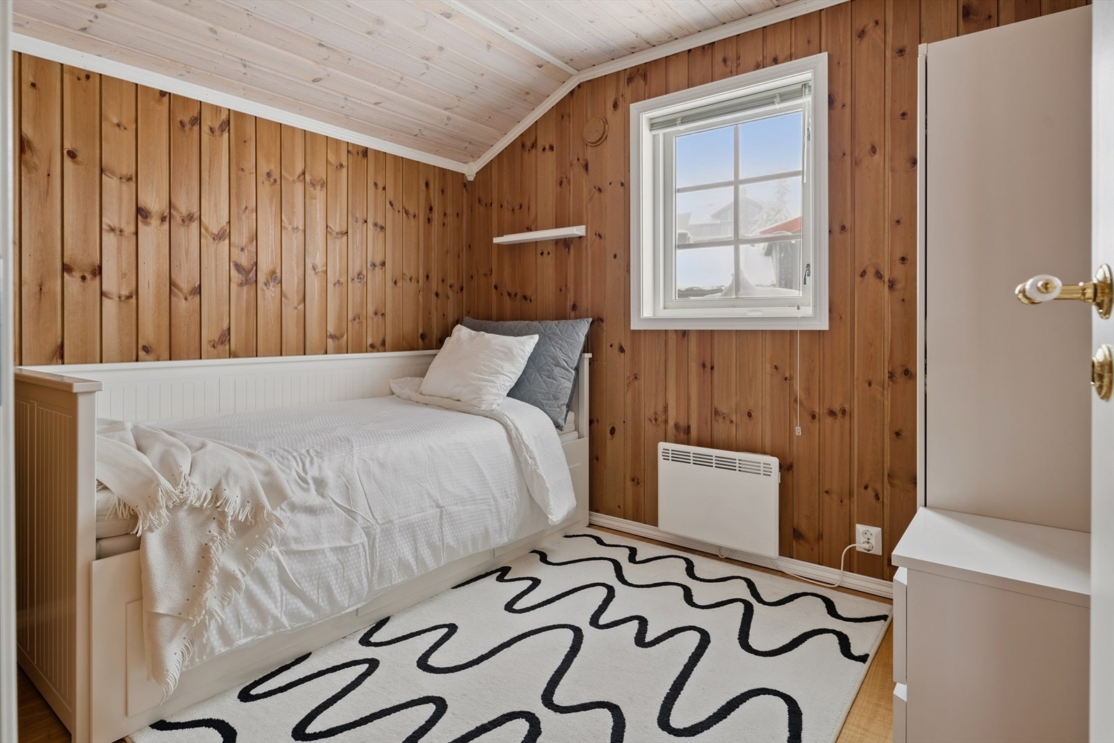 Et av soverommene i andre etasje, innredet med en praktisk dagseng. Galleribilde