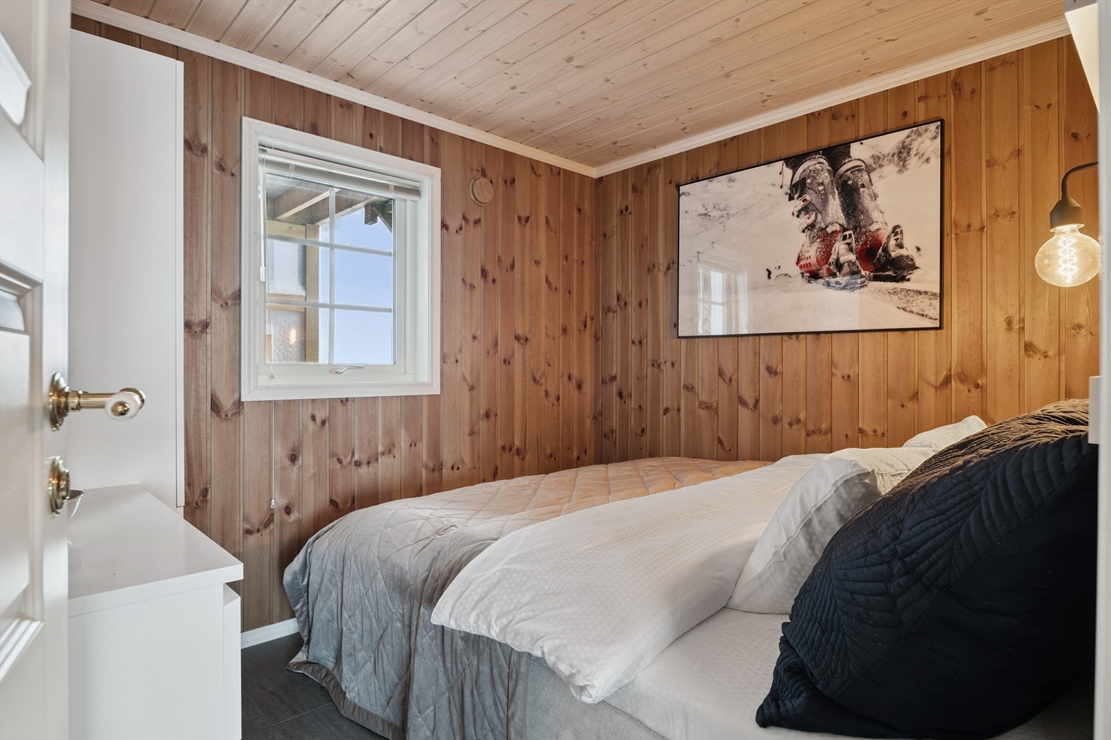 Hytta har totalt fire soverom. Her er ett av soverommene i første etasje. Galleribilde