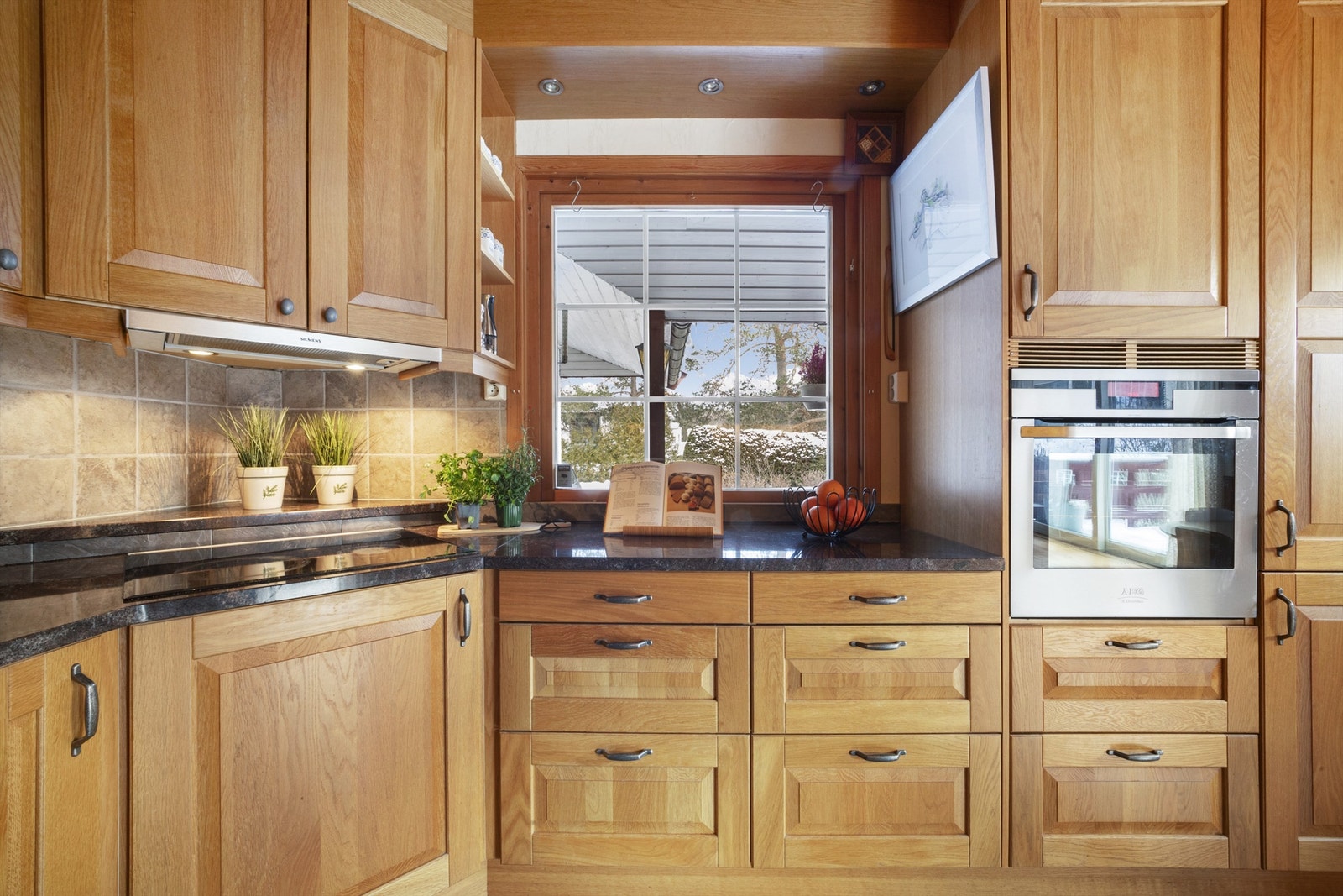 Kjøkkenet er utstyrt med integrert platetopp og stekeovn, samt innbygget oppvaskmaskin og kjøleskap Galleribilde