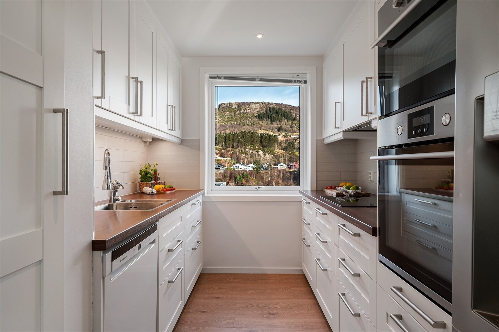 - Tidløst kjøkken med hvite profilerte fronter og takhøye overskap som gir et sømløst uttrykk - Galleribilde