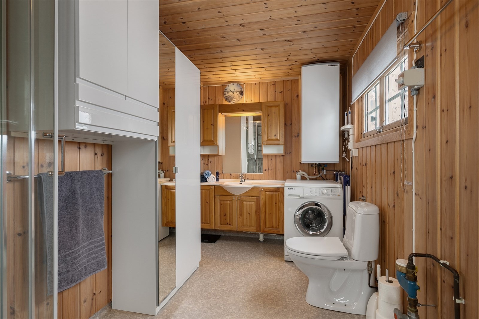 Badet er funksjonelt innredet med servantinnredning, dusjkabinett, toalett, servant og opplegg for vaskemaskin. Galleribilde