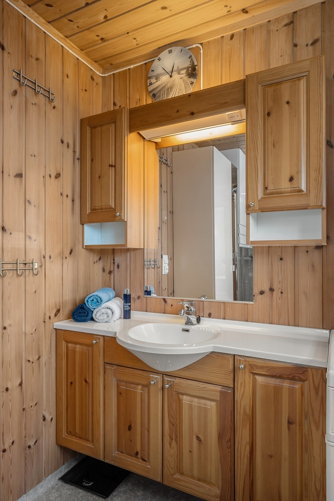 Baderomsinnredning med trehvite fronter. God oppbevaringsplass i over- og underskap. Galleribilde