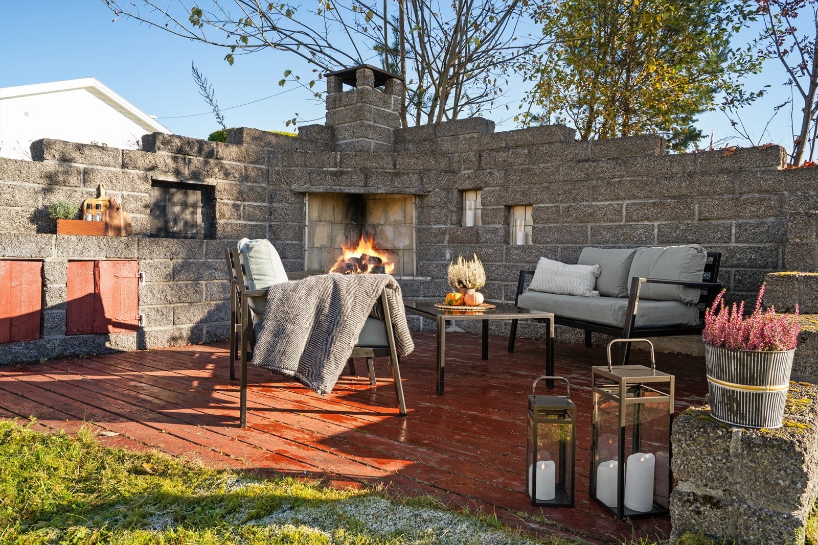 Stemningsfull uteplass med murt utepeis som skaper en koselig atmosfære - perfekt for hyggelige kvelder året rundt. Den romslige plassen gir gode muligheter for både sittegruppe og servering, og blir et naturlig samlingspunkt for familie og venner Galleribilde