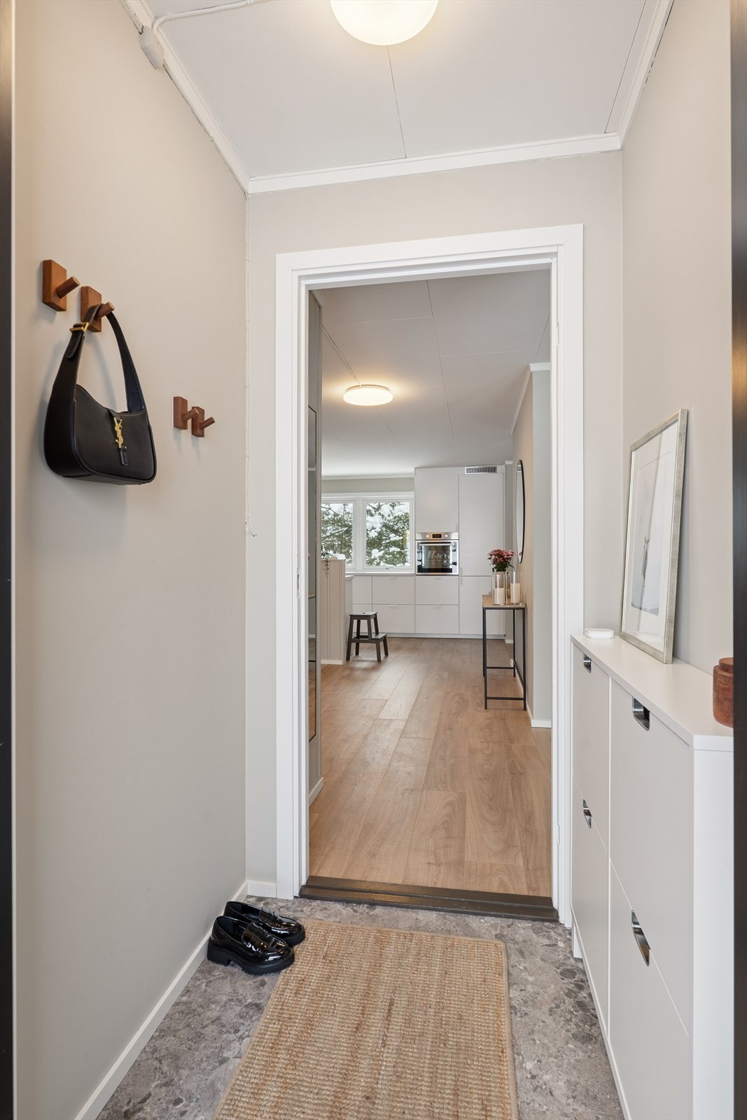 Velkommen inn i en lys og innbydende entré med praktisk oppbevaring og direkte adkomst til det åpne oppholdsrommet Galleribilde