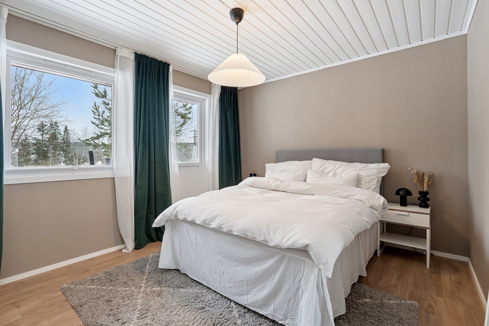 Lekkert og rolig hovedsoverom med behagelige fargetoner og store vindusflater som slipper inn rikelig naturlig lys. En innbydende og avslappende sone - perfekt for å trekke seg tilbake Galleribilde