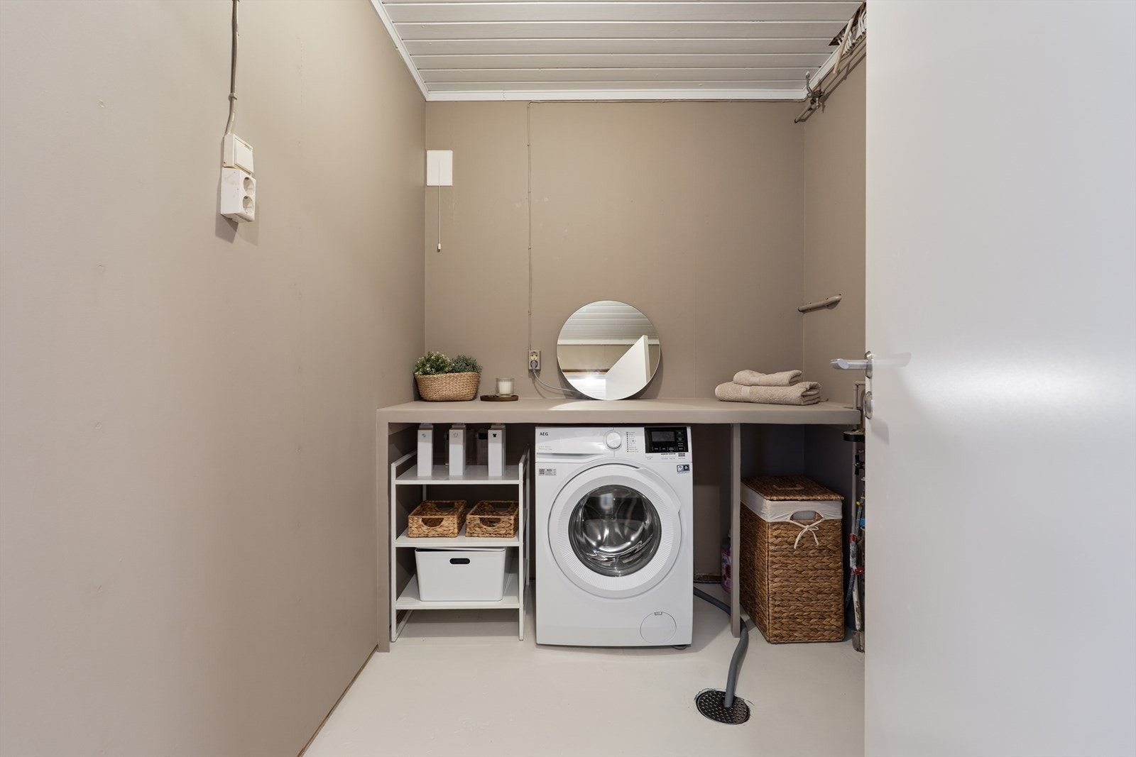 Praktisk vaskerom med god benkeplass, oppbevaring og plass til både vaskemaskin og tilbehør. I opprinnelige tegninger er rommet godkjent til bod. Galleribilde