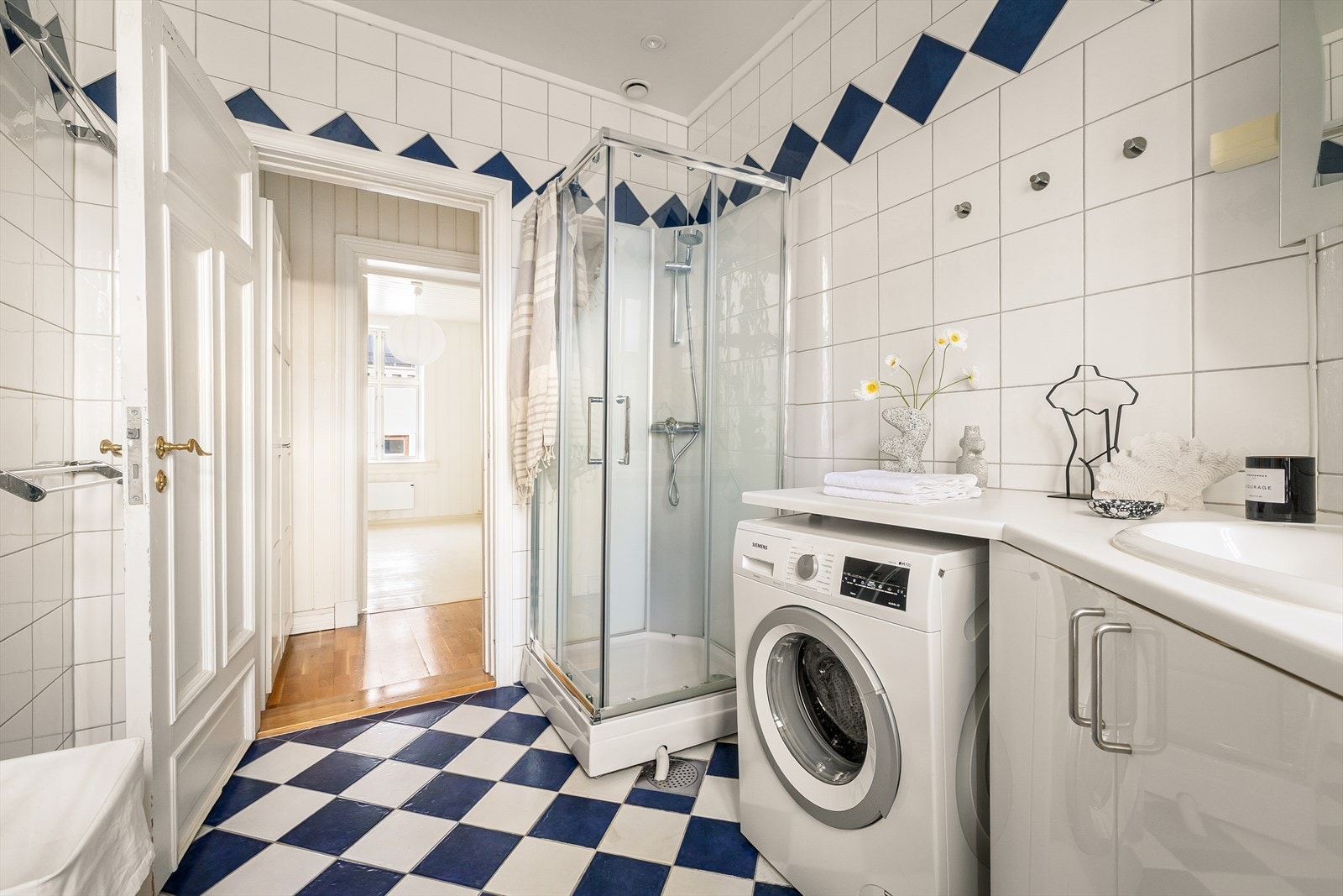 Badet er for øvrig ustyrt med dusjkabinett, servant med skapinnredning, speilskap med belysning og opplegg for vaskemaskin. Badet har naturlig oppdriftsventilasjon. Galleribilde