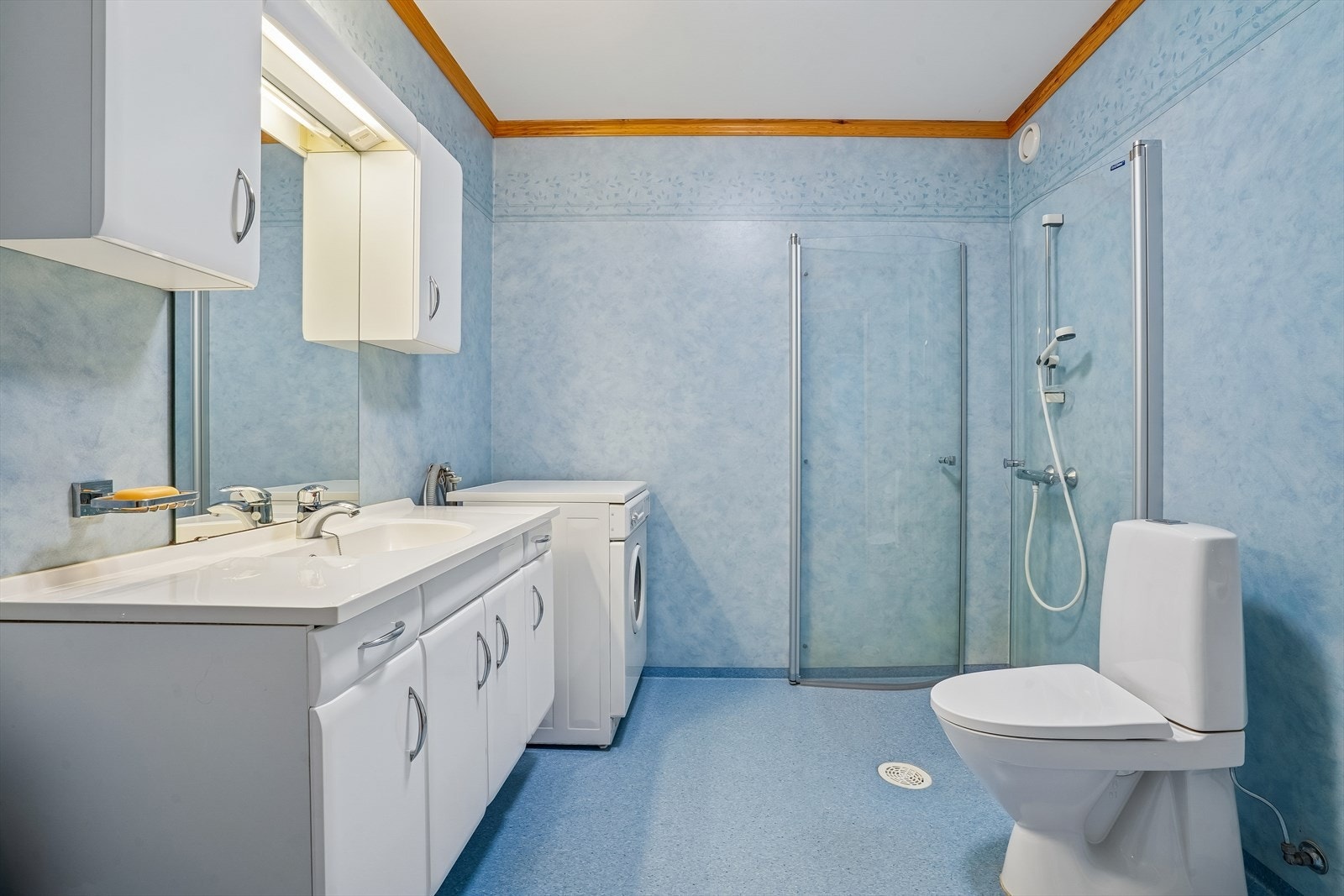 Her er det en åpen dusjløsning med innfellbare glassdører fra 2018 og vinylbelegg på gulv og vegger. Galleribilde