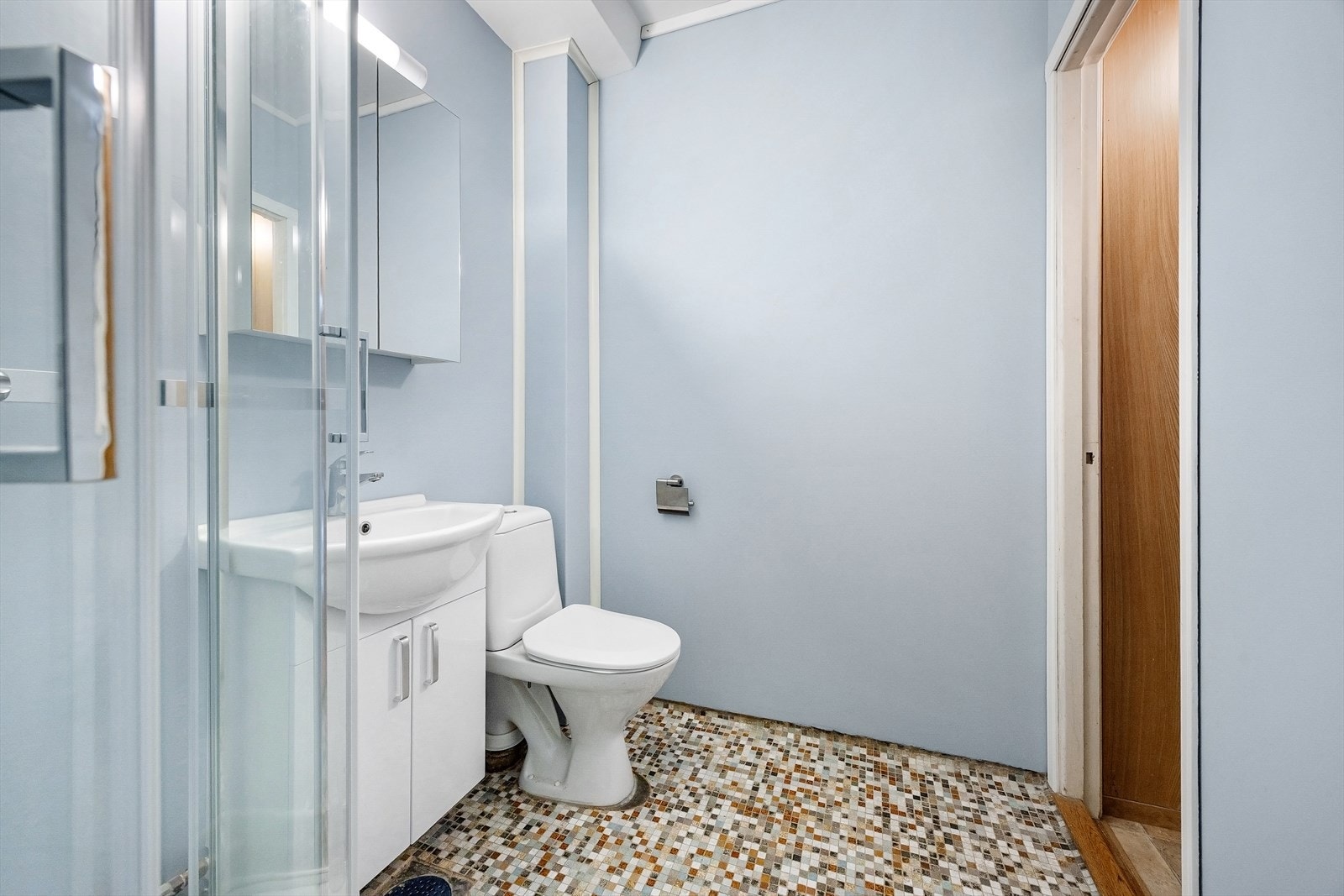 Eldre bad med dusjkabinett, servant m/tilhørende innredning og wc. Galleribilde