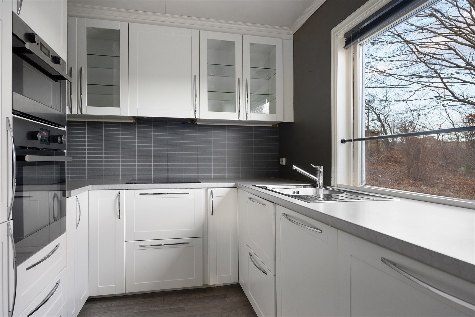 Kjøkkeninnredningen er lys og moderne med integrerte hvitevarer Galleribilde