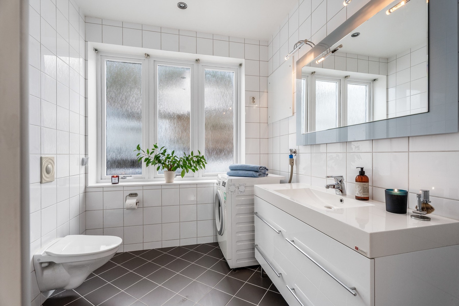 Badet er stort nok til å ha plass til vaskemaskin og det er varmekabler i gulv. Galleribilde